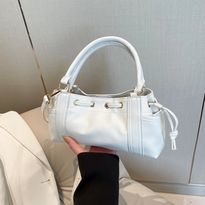 White leather mini tote bag with gold eyelets and drawstring accents for casual daily use