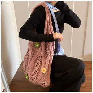 Détail d'un sac cabas en tricot rose avec fleurs 3D faites main porté à l'épaule