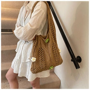 Détail du sac cabas en maille marron avec fleurs brodées à la main et texture ajourée