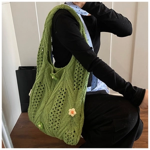 Détail du sac fourre-tout au crochet vert avec accents floraux et texture en maille tricot