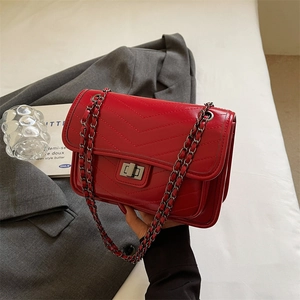 Red quilted V-pattern shoulder bag with metallic chain strap and twist lock closure