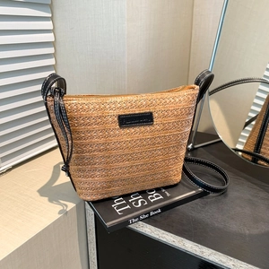 Fashionable woven bucket bag with black leather trim and white contrast stitching detail