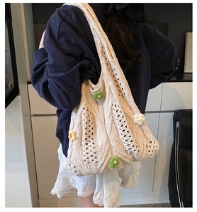 Détail d'un sac cabas en tricot beige avec des fleurs 3D délicates et texture tissée