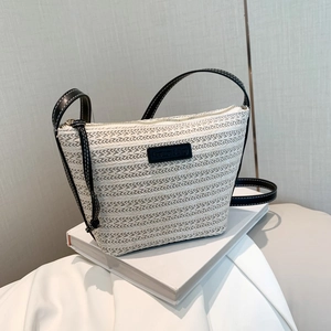 Large straw bucket bag with black leather straps and zipper closure for summer beach use