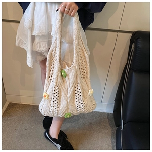 Détail macro du sac à main en maille blanche avec des fleurs au crochet en 3D