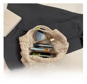 Top view of beige woven tote showing spacious interior with phone and cosmetics