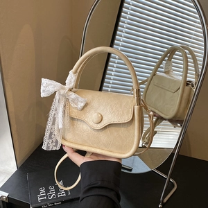 Chic beige cream saddle bag with lace bow detail and soft wrinkled faux leather finish