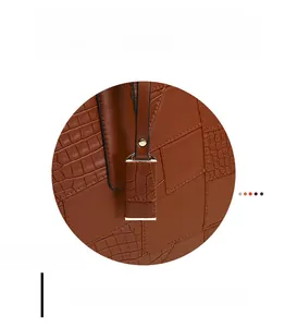 Detailed macro view of reinforced stitching and metallic rivets on brown tote bag strap