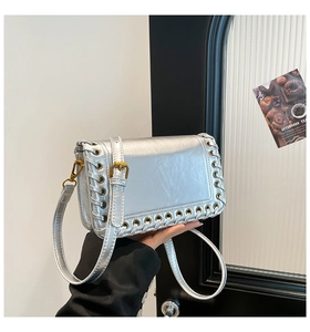 Detail of silver metallic square bag with woven edges and adjustable shoulder strap