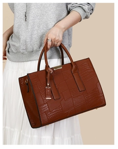 Close-up of vintage brown embossed crocodile pattern leather and gold metal hardware detail