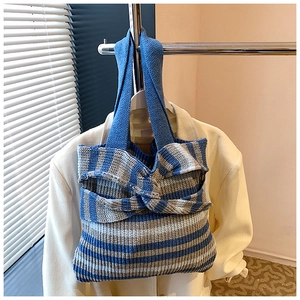 Detailed close-up of blue and white striped knit tote bag with decorative knot design