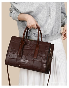 Detail of vintage embossed tote bag in burgundy brown leather with crocodile texture