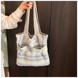 Detail of colorful striped knit tote bag with decorative knot and textured fabric