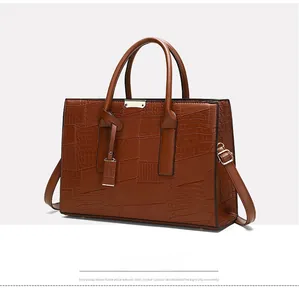 Close-up of caramel crocodile-embossed tote bag with adjustable shoulder strap hooks