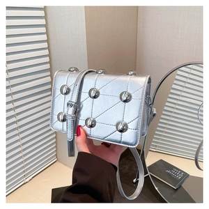 Silver metallic crossbody bag with round rivets and geometric stitching on the flap