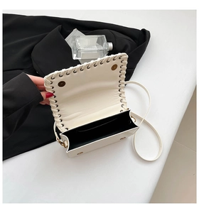 Detail view of the white square bag featuring woven stitching and double magnetic snap closure