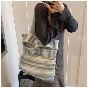 Detailed knit texture of large tote bag with striped color-block and bow design