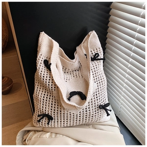 Détail du sac cabas en maille beige avec nœuds décoratifs noirs pour l'été