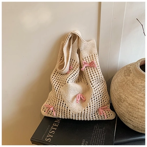 Gros plan détaillé du sac cabas en crochet beige avec des nœuds roses et une texture ajourée