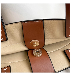 Detailed macro view of magnetic clasp closure on the leather shoulder handbag
