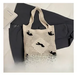 Détail du sac fourre-tout tissé crème avec motif au crochet ajouré et nœuds noirs