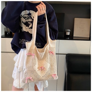 Détail du sac cabas au crochet avec nœuds roses et maille évidée au design raffiné