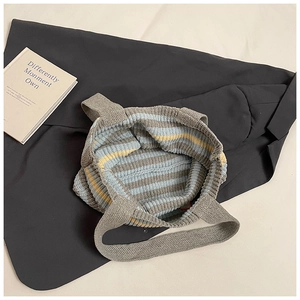 Detailed close-up of thick knitted striped tote bag texture in blue gray and yellow
