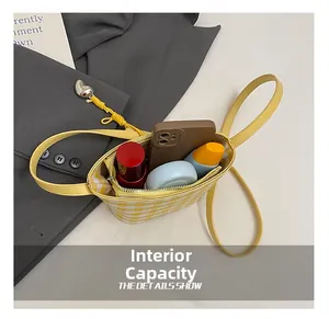 Internal capacity of the yellow plaid bucket bag showing space for phone and makeup
