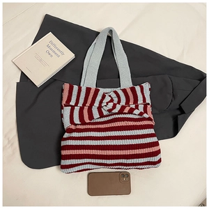 Detailed close-up of a striped knit tote bag featuring a decorative front knot design