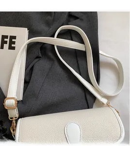 Detail of cream white faux leather shoulder bag with adjustable strap and golden metal buckle