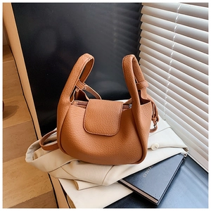 Detail of caramel brown lychee texture leather shoulder bag with sleek flap closure