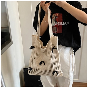 Gros plan détaillé du sac cabas en crochet beige avec maille et nœuds noirs