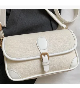 Detailed macro view of the cream white lychee pattern leather and gold metal buckle