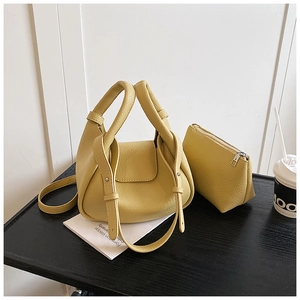 Macro shot of yellow leather tote set including shoulder bag and zipper wallet pouch