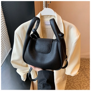 Close-up of black lychee grain leather tote bag with round handles and detachable strap
