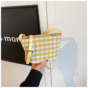 Detail of yellow and white checkered canvas bag with adjustable leather shoulder strap