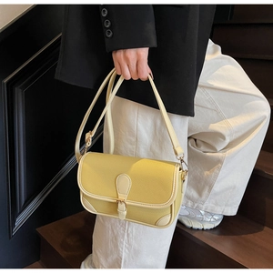 Detailed macro view of mustard yellow lychee pattern leather shoulder bag texture