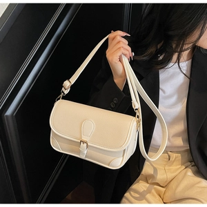 Detail of beige litchi grain leather shoulder bag with gold metal buckle and flap