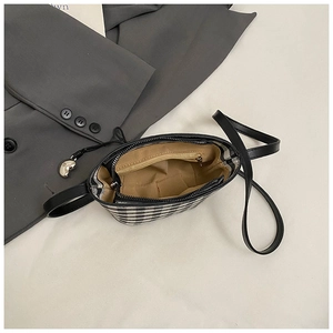 Close-up of checkered canvas bag interior with a zipper pocket and heart charm
