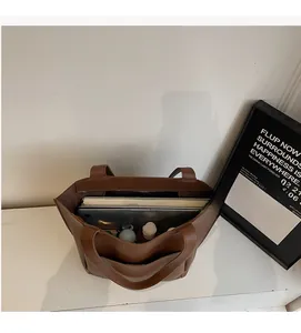 Top view of brown leather tote bag interior showing large capacity for laptop and books