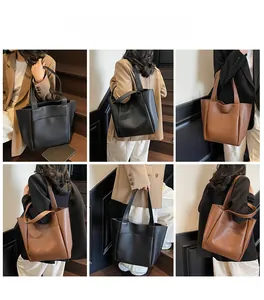 Detail view of large lychee leather tote bags in black and caramel brown for office use