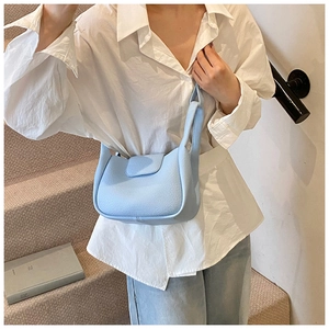 Detailed texture of light blue pebble grain faux leather hobo bag with flap closure