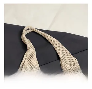 Detailed macro view of the cream woven shoulder strap with hollow mesh knit texture