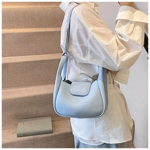 Close-up of light blue lychee pattern leather shoulder bag with wide strap detail