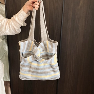 Contrast color knitted tote bag with blue and beige stripes and a knot bow detail