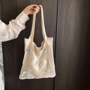 Sac cabas en crochet beige avec nœuds bleus et motifs cœurs pour le style d'été