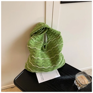 Detail of green and white woven handbag with wavy knit pattern and hollow design