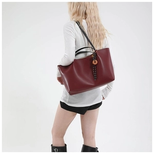 Large burgundy leather tote bag with black straps and wood charm pendant for women