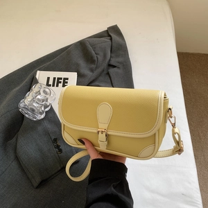Pale yellow pebble leather shoulder bag with buckle flap and beige piping details