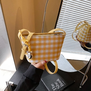 Yellow and white checkered canvas bucket bag with adjustable leather strap and heart charm